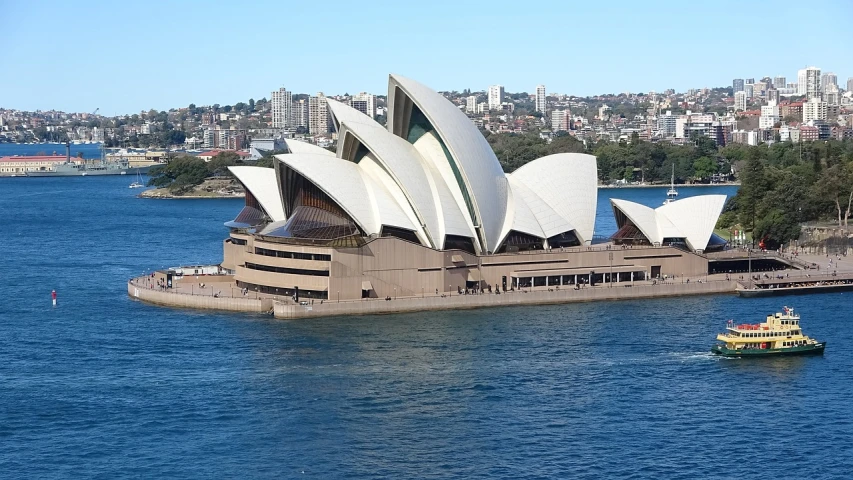 a large building sitting on top of a body of water, inspired by Sydney Carline, from wikipedia, sails, spacious, instrument