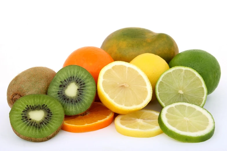 a pile of fruit sitting on top of a white surface, istockphoto, kiwi, lemonade, orange yellow