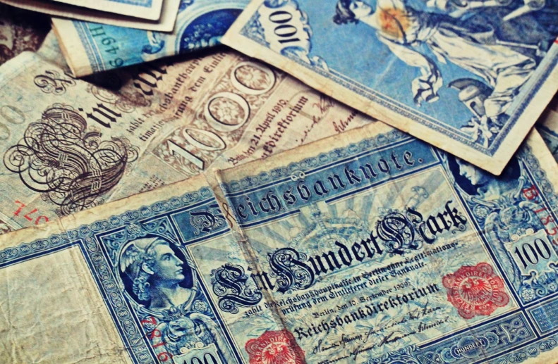 a pile of old paper money sitting on top of a table, by Daniel Lieske, trending on pixabay, art nouveau, blue - print, set in ww2 germany, mobile wallpaper, vintage - w 1 0 2 4