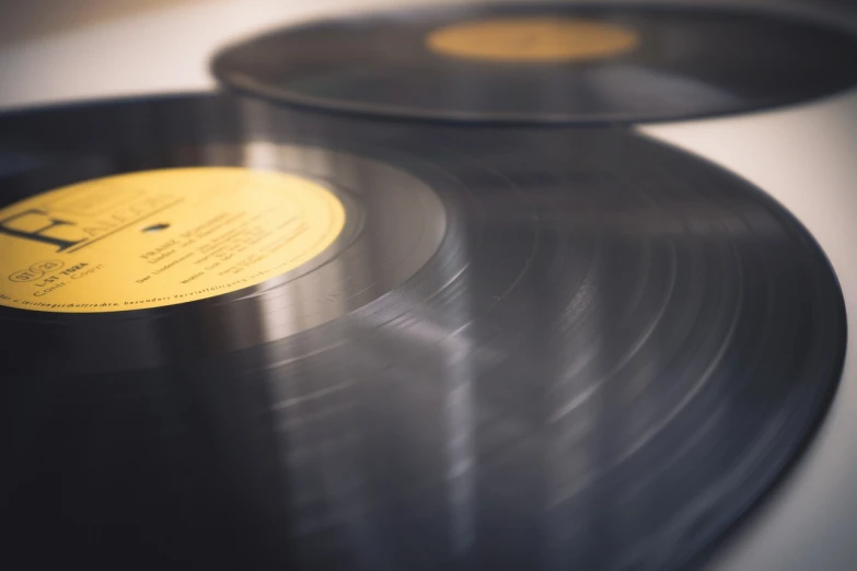 a couple of vinyl records sitting on top of a table, an album cover, by Jakob Gauermann, shutterstock, non blurry, stock photo, close up photo, lined up horizontally