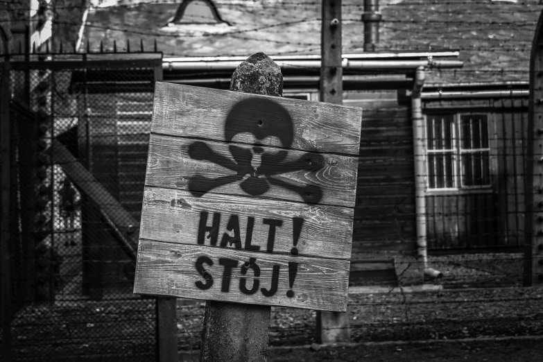 a wooden sign with a skull and crossbone on it, by Oskar Lüthy, flickr, graffiti, b&w hasselblatt, military base, stop sign, ❤🔥🍄🌪
