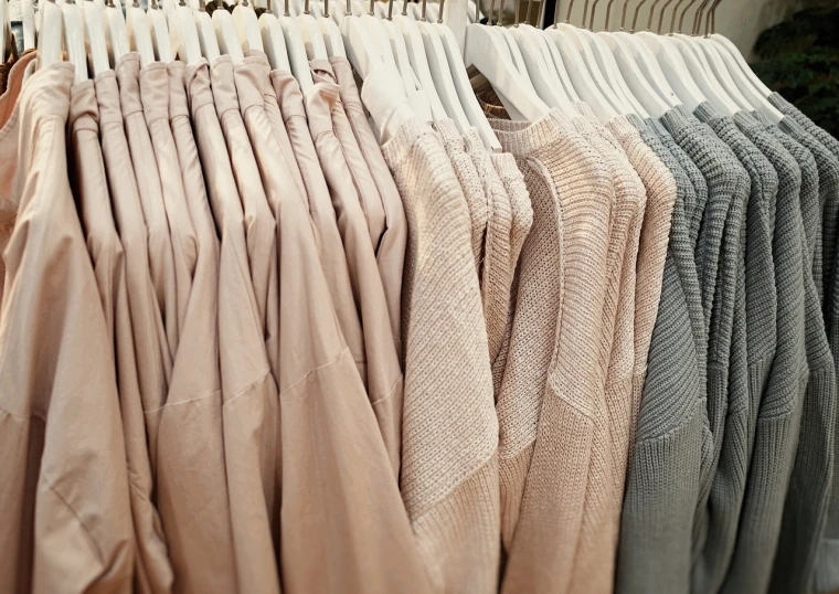 a row of clothes hanging on a rack, by Matija Jama, warm and soft and subdued colors, pastel soft colors, long sleeves, close up to a skinny