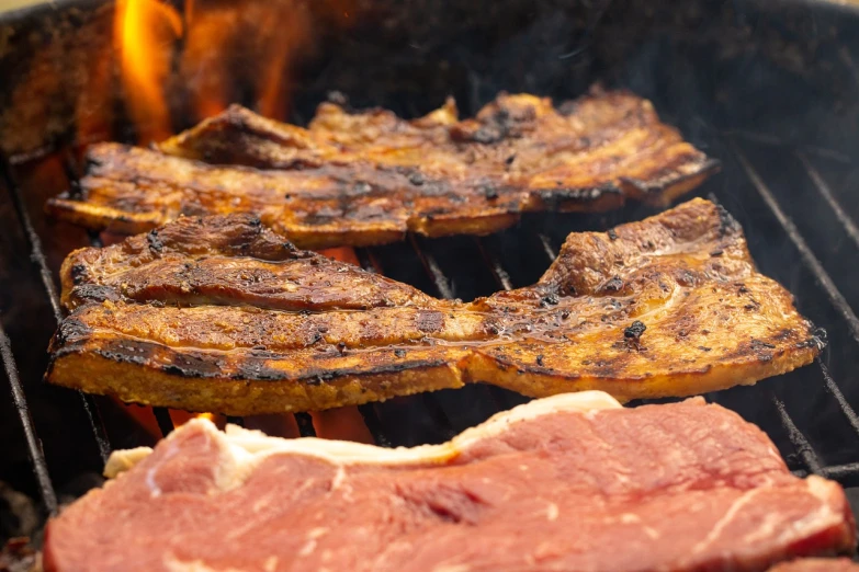 steaks cooking on a grill with flames in the background, a picture, by Joe Bowler, pexels, renaissance, bacon, 4k detail, chilean, stacked image