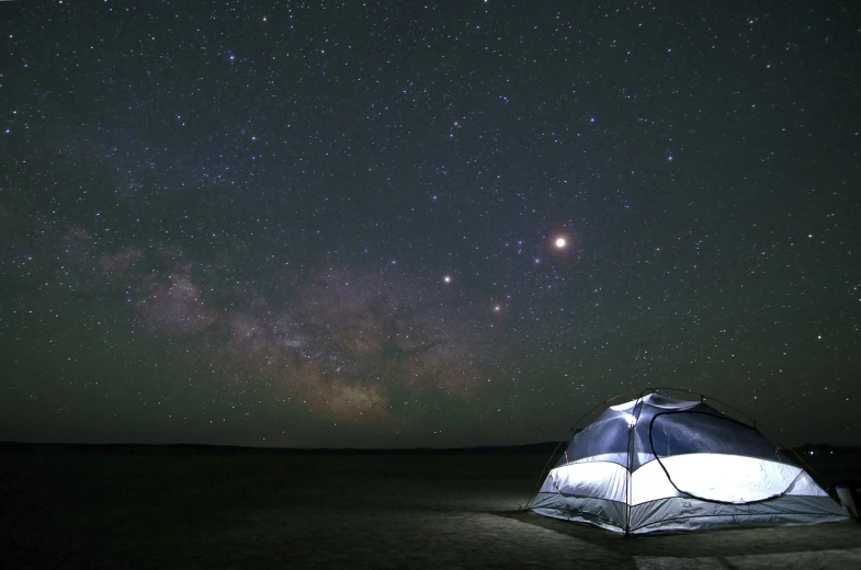 a tent sitting in the middle of a field under a sky full of stars, by Dennis Ashbaugh, mars vacation photo, photograph credit: ap, sitting on the beach at night, visible planets in the sky