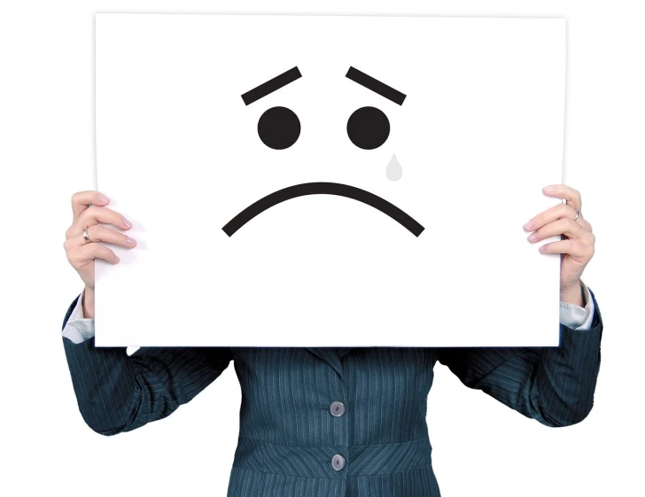 a woman holding a sign with a sad face drawn on it, by Itō Seiu, pixabay, isolated on white, tears, bad print, facepalm