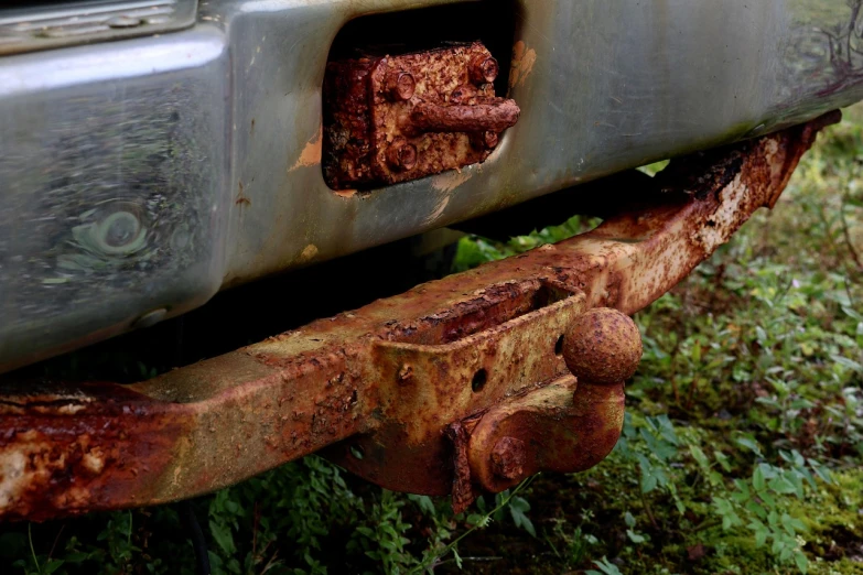 a close up of a rusted bumper on a truck, by Richard Carline, muddy ground, mystical setting, square jaw, highly_detailded