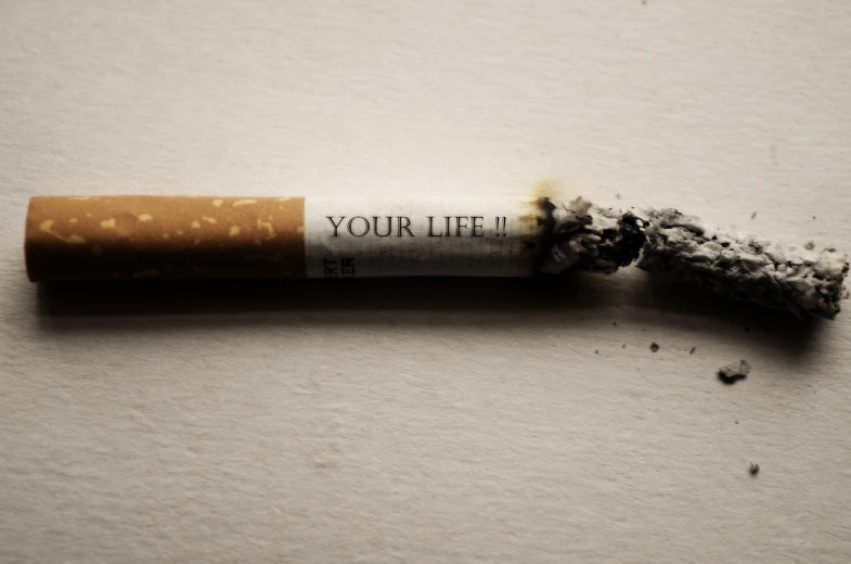 a cigarette with the words your life written on it, hyperrealism, losing control over one's life, profile picture, tumours, macros shot