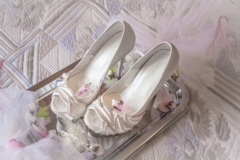 a close up of a pair of shoes on a tray, a picture, romanticism, white and silver, sakura, satin silver, basic photo