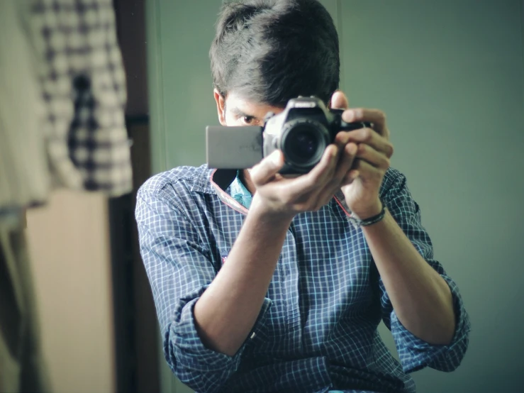 a man taking a picture of himself with a camera, a picture, inspired by Saurabh Jethani, looking in mirror, focused shot, low camera position, cute photograph