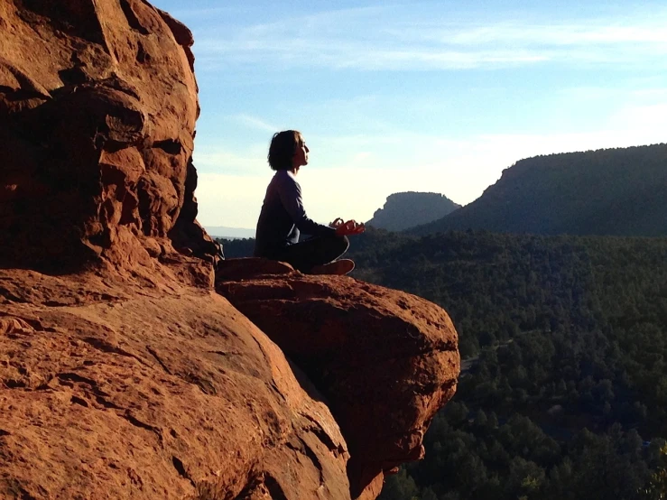 a person sitting on top of a large rock, by Anna Haifisch, sedona's cathedral rock bluff, zen meditation, profile pic, screengrab