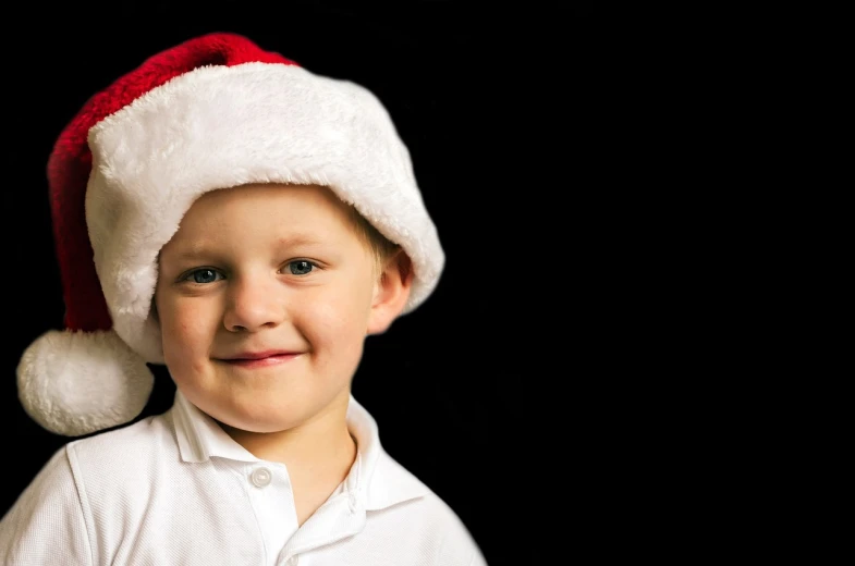 a close up of a child wearing a santa hat, a photo, standing with a black background, blond boy, wallpaper!, child hybrid