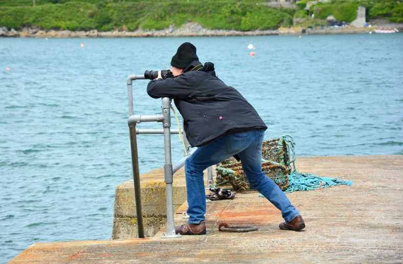 a man taking a picture of a body of water, a picture, figuration libre, breton cap, very accurate photo, david a trampier, cannon photo