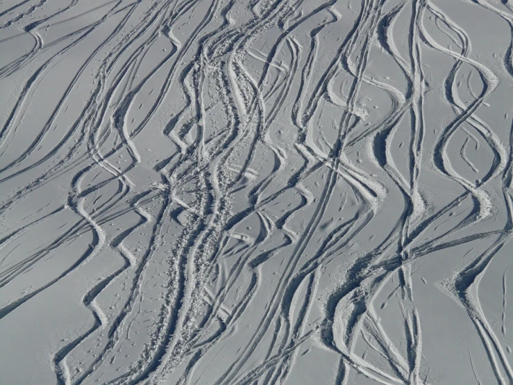 a person riding skis down a snow covered slope, a stipple, inspired by Jules Olitski, flickr, op art, intricate wrinkles, serpentine curve!!!, texture detail, vertical lines