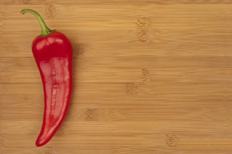 a red pepper sitting on top of a wooden cutting board, by Juan O'Gorman, renaissance, banner, high-resolution photo, bamboo, high res photo