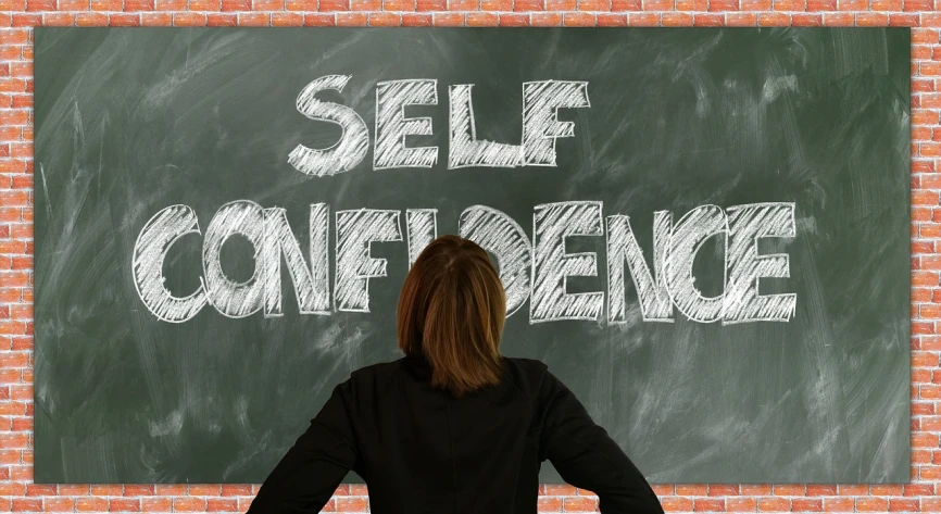 a woman standing in front of a chalkboard that says self confidence, by Gina Pellón, trending on pixabay, surrealism, mirrored, view from below, 🦩🪐🐞👩🏻🦳, thumbnail