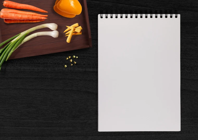 a notepad sitting on top of a wooden cutting board, a picture, by Andrei Kolkoutine, trending on pixabay, conceptual art, still life vegetables, black flat background, orange and white color scheme, packshot