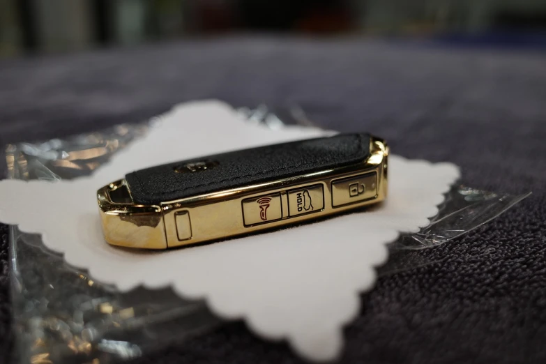 a cell phone sitting on top of a piece of paper, dada, made in gold, finely detailed car, mochiduki key, side shot