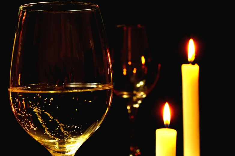 a close up of a wine glass with a candle in the background, a digital rendering, pexels, romanticism, white wine bottle, detailed zoom photo, dark lit candles, high res photo