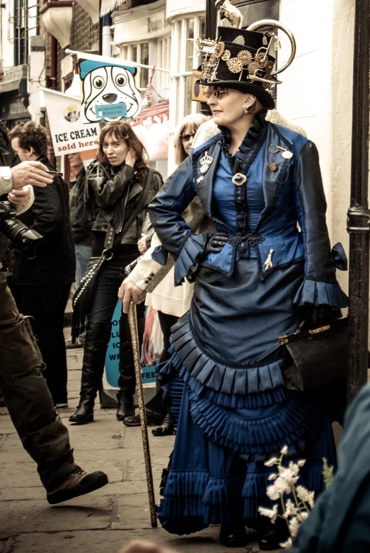 a woman in a blue dress is walking down the street, flickr, renaissance, steam punk party, in london, onlookers, portrait of lady mechanika