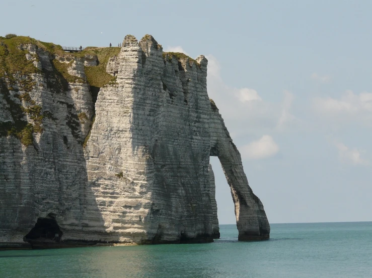 a large rock formation in the middle of a body of water, romanticism, the normandy landings, white stone arches, dominance, sail