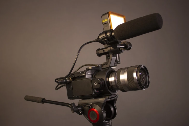 a close up of a camera on a tripod, volumetric lighting - h 7 6 8, sony camera, microphone, against dark background