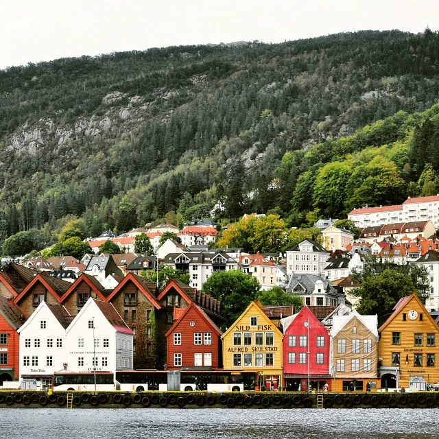 a row of houses next to a body of water, by Jesper Knudsen, pexels, renaissance, scandinavian / norse influenced, hills, colorful building, stock photo