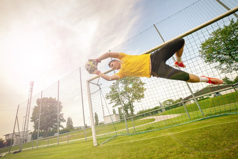 a man jumping in the air to catch a soccer ball, a picture, by Jakob Gauermann, shutterstock, figuration libre, netting, sunny day, commercial shot, rectangle
