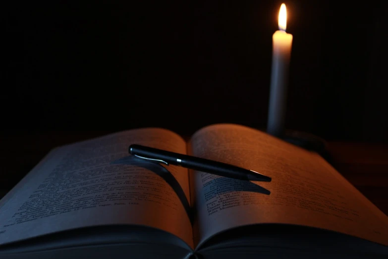 a pen sitting on top of an open book, by Aleksander Gierymski, pixabay, romanticism, candlelight, istockphoto, last photo, spooky photo