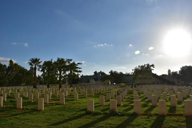 a cemetery filled with lots of tombstones under a blue sky, les nabis, sun down, battlefield, reportage photo