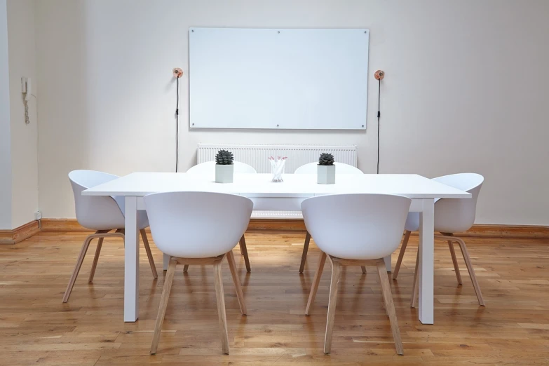 a white table and chairs in a room, pexels, minimalism, whiteboard, speakers, imperial officers in white, laura watson