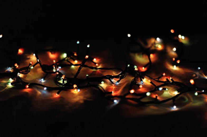 a bunch of lights that are on a table, a picture, by Amelia Peláez, christmas lights, dark background”, autumn lights colors, dark background ”