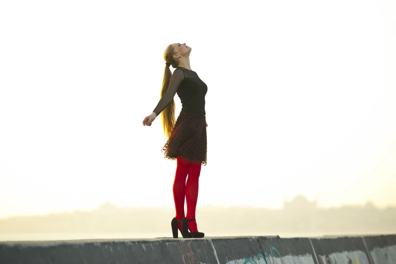 a woman standing on top of a skateboard ramp, a picture, inspired by Louisa Matthíasdóttir, renaissance, in red velvet stockings, beautiful backlight, cinematic outfit photo