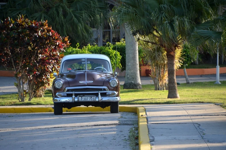 a classic car parked on the side of the road, flickr, in marijuanas gardens, late afternoon, p. j. n, about to step on you