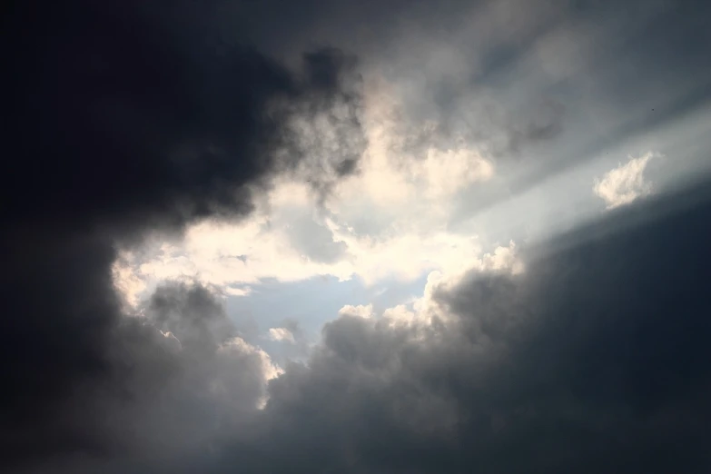 a large jetliner flying through a cloudy sky, a picture, light and space, god rays through fog, blackened clouds cover sky, sun after a storm, loots of clouds