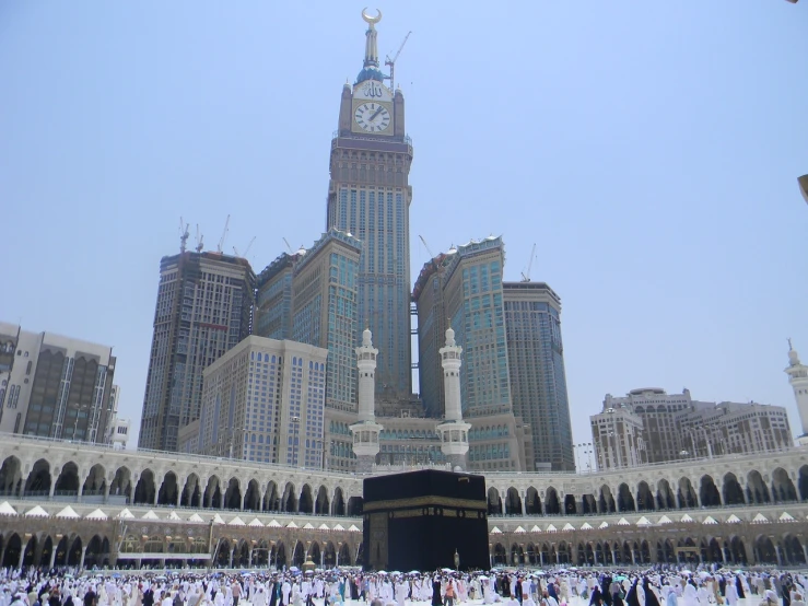 a group of people standing in front of a clock tower, by Susan Heidi, flickr, hurufiyya, the masjid al-haram in mecca, palace floating in heaven, gorgeous buildings, terminal