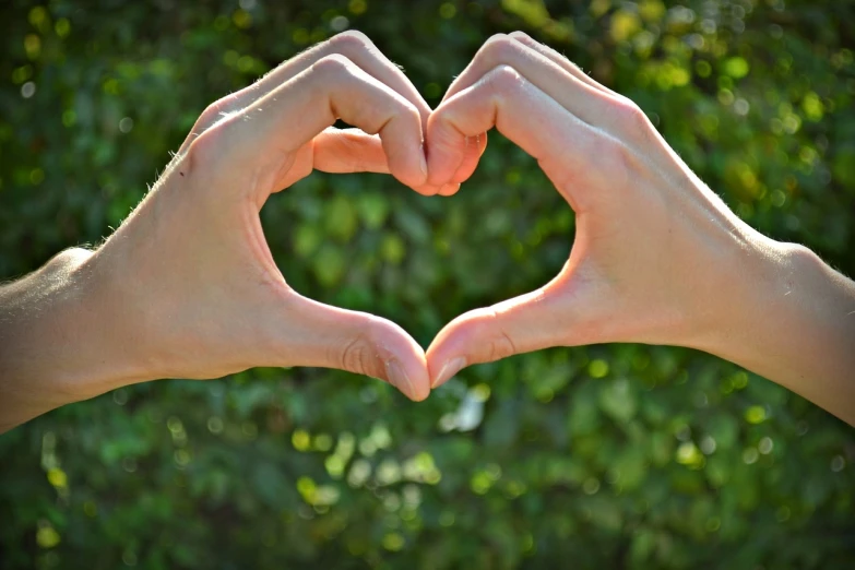 a person making a heart with their hands, by Linda Sutton, photostock, environment friendly, lovers, high res