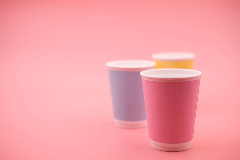 three cups sitting next to each other on a pink surface, a pastel, by Kinichiro Ishikawa, shutterstock, paper cup, half body photo, miniature product photo, colored accurately