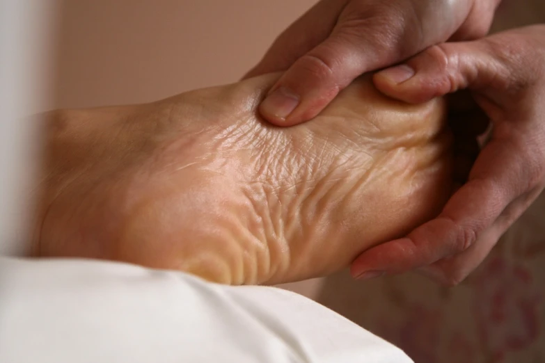 a close up of a person touching a foot, flickr, garner holt, paradise garden massage, backwards, ben watts