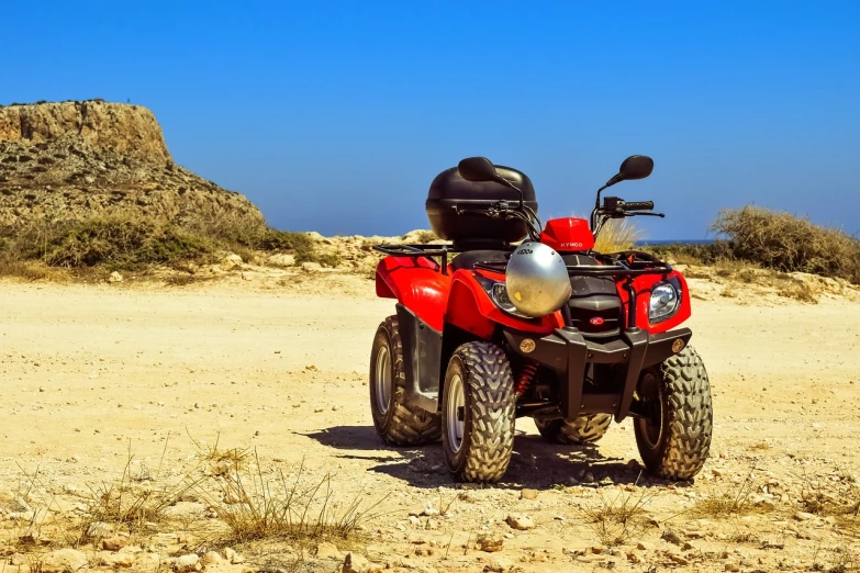 a red four wheeler parked in the desert, a photo, shutterstock, costa blanca, stock photo, beautiful sunny day, watch photo