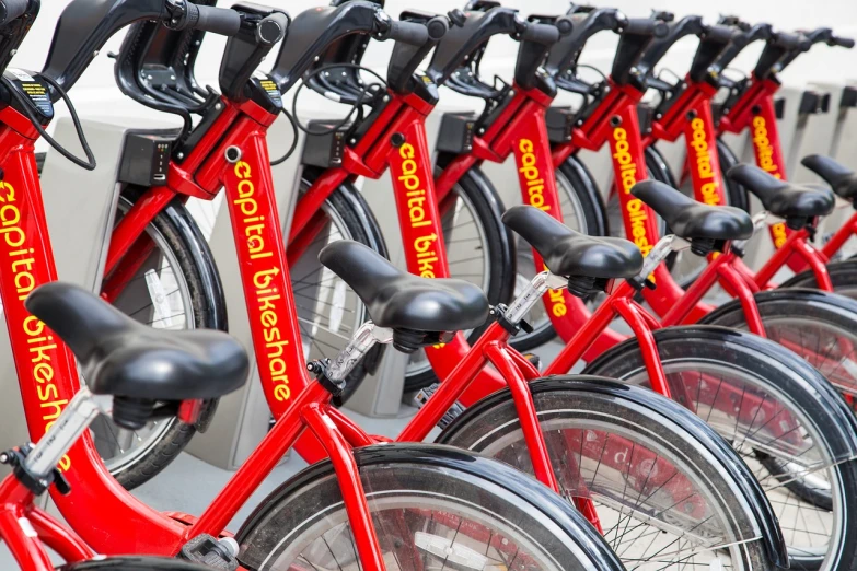 a row of red bikes parked next to each other, by Jon Coffelt, shutterstock, black and yellow and red scheme, spinning, advertising photo, nyc