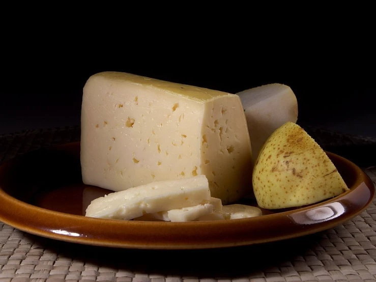 a piece of cheese sitting on top of a brown plate, by Pedro Pedraja, flickr, pear, trio, high qualitt, whites