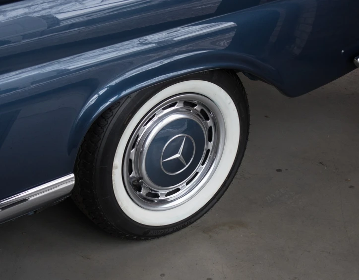 a blue car with a white rim parked in a garage, dribble, arabesque, face detail, restored, mercedez benz, detailed - wheels