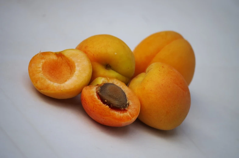 a group of apricots sitting on top of a table, bauhaus, hyper detailed photo, close-up product photo, closeup photo, cut