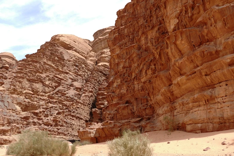 a person riding a horse through a canyon, les nabis, wadi rum, highly detailed rock structures, 33mm photo