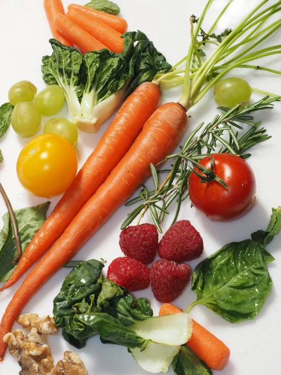 a white plate topped with carrots, raspberries, and other vegetables, a picture, by Dietmar Damerau, figuration libre, scientific photo, green and orange theme, morning detail, not cropped