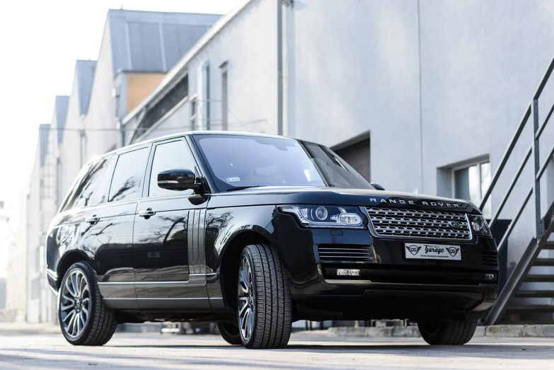 a black range rover parked in front of a building, a picture, by Adam Marczyński, shutterstock, basic photo, detailed alloy wheels, high detailed photo, ultra wide