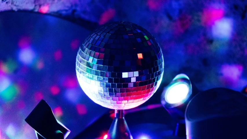 a disco ball sitting on top of a table, by Joe Bowler, pexels, headlights shine with neon light, seventies, shiny scales, ✨🕌🌙