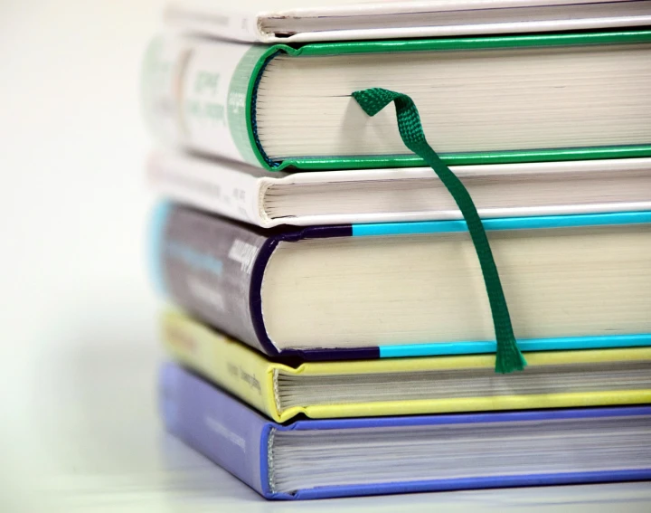 a stack of books sitting on top of each other, a picture, by Dietmar Damerau, green and purple, ribbon, read a directory book, istockphoto