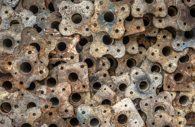 a pile of rusty metal pieces with holes in them, inspired by Max Ernst, shutterstock, high resolution product photo, traditional chinese textures, 35 mm product photo”, piles of bones