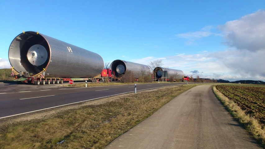 a couple of large pipes sitting on the side of a road, a picture, by Werner Gutzeit, flickr, zeppelin dock, big pods, horizon forbideen west, eldenring